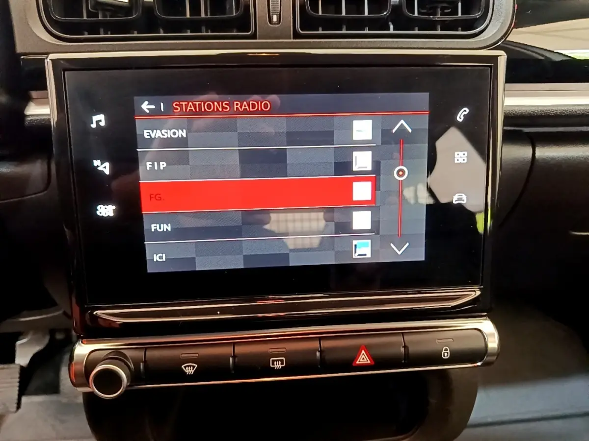 Vue rapprochée de l’écran tactile central du tableau de bord de la Citroën C3 2021, affichant les stations radio.