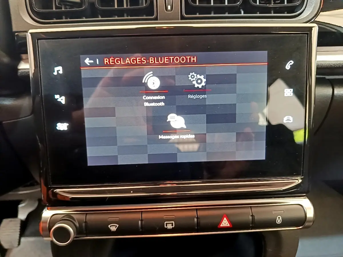 Écran tactile central affichant les réglages Bluetooth dans l’habitacle noir d’une Citroën C3 blanche, vue de face.