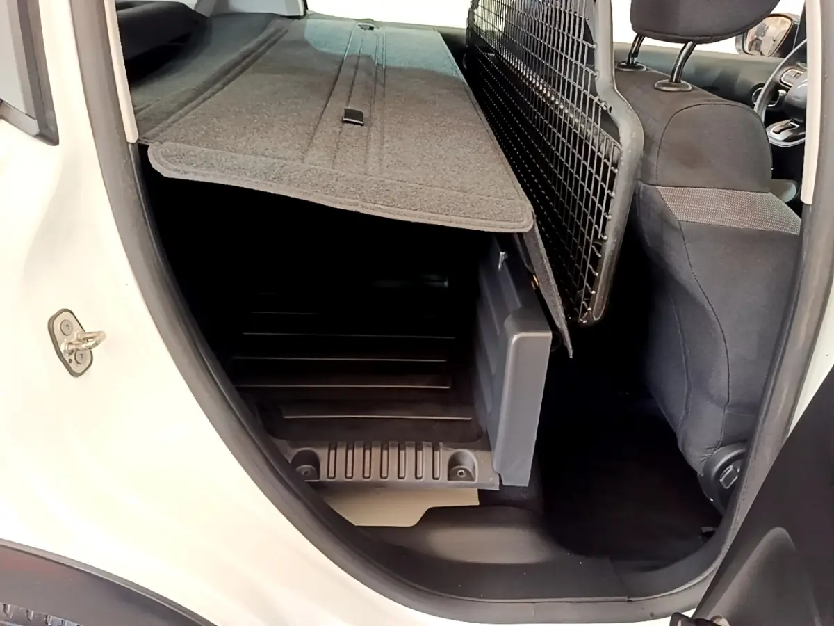 Vue intérieure côté droit du coffre d'une Citroën C3 blanche 2021 avec banquette rabattue et séparation grillagée.
