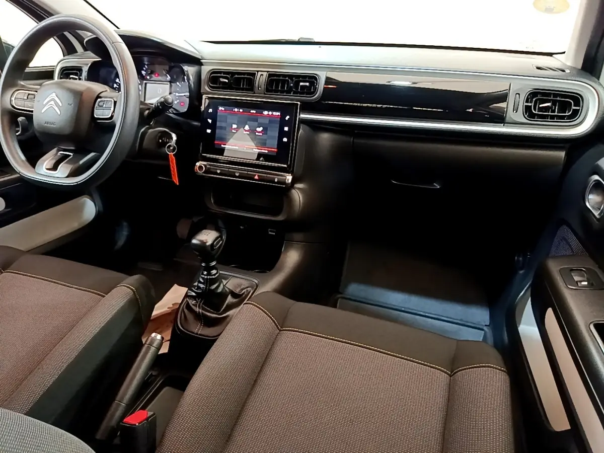 Vue intérieure avant de la Citroën C3 2021 avec tableau de bord noir, écran tactile central et volant multifonctions.