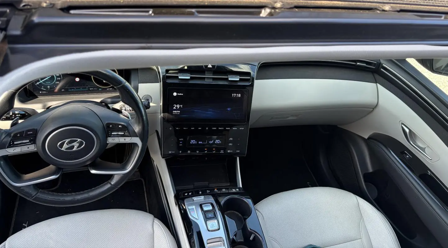 Intérieur clair du Hyundai Tucson 2022, vue de dessus sur le tableau de bord, volant cuir et console centrale tactile.
