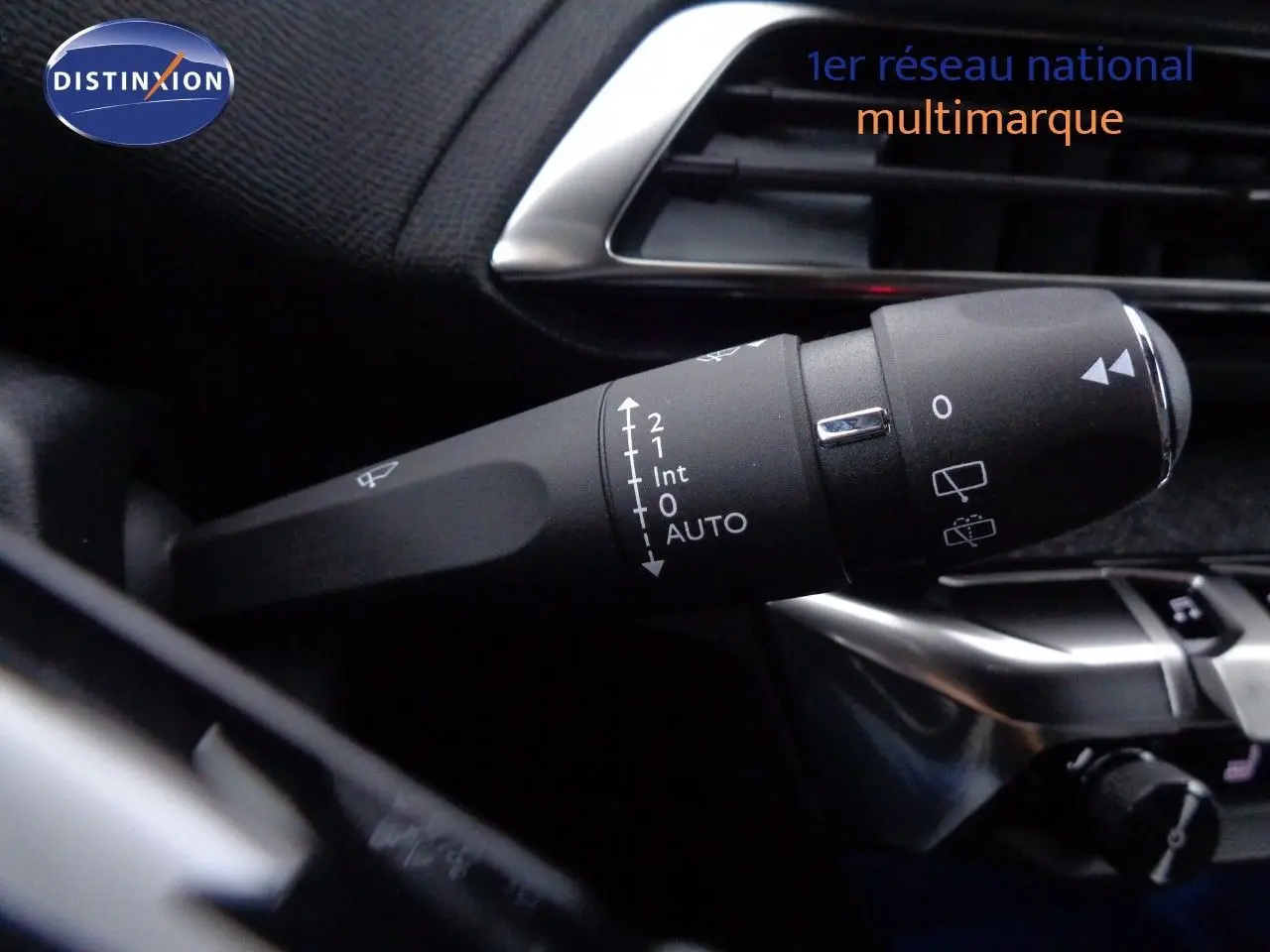 Gros plan sur la commande d'essuie-glace à gauche du volant dans l'habitacle d'un Peugeot 3008 bleu 2023.
