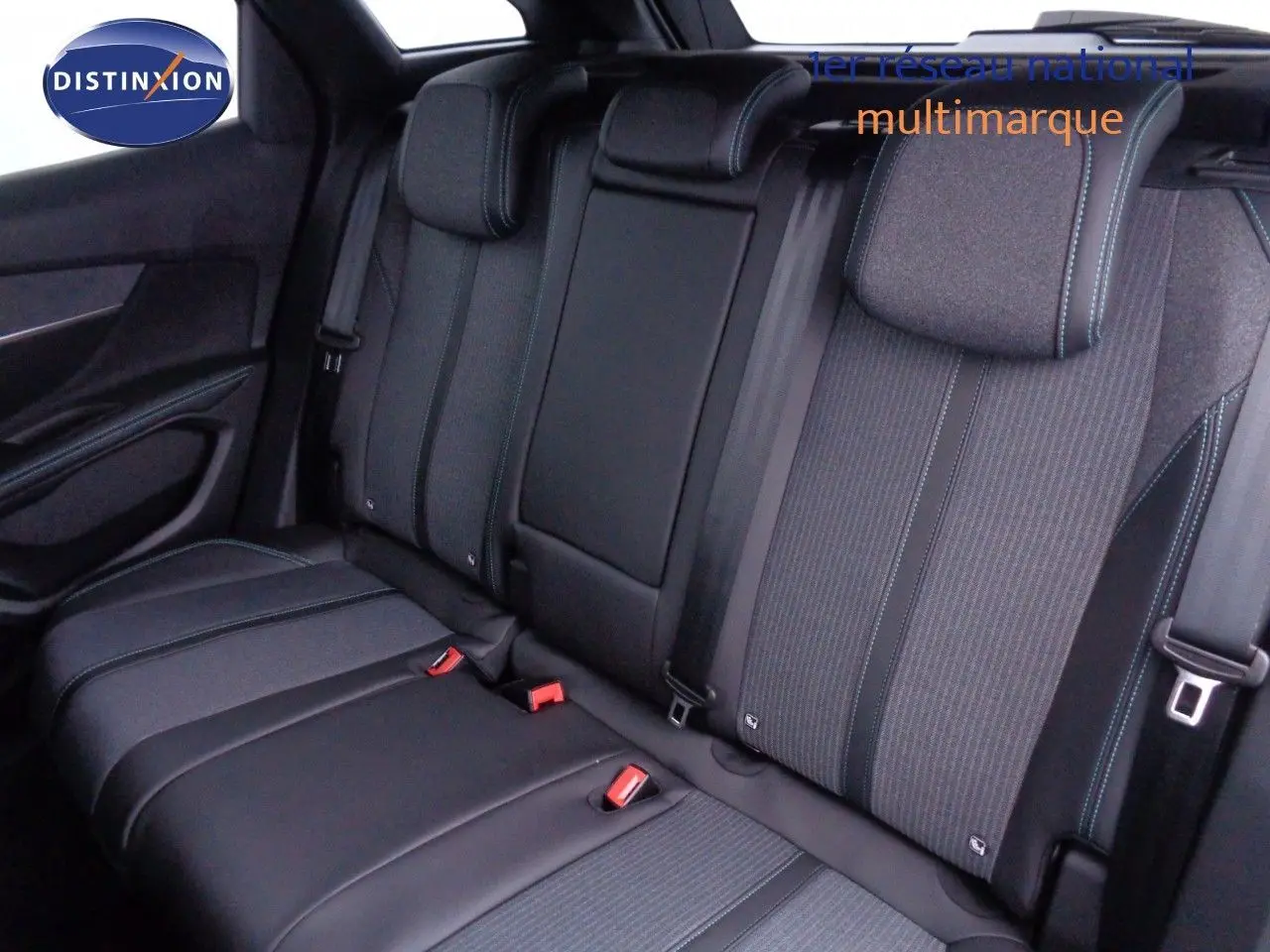 Vue intérieure des sièges arrière en tissu et cuir noir du Peugeot 3008 2023, avec surpiqûres bleues visibles.