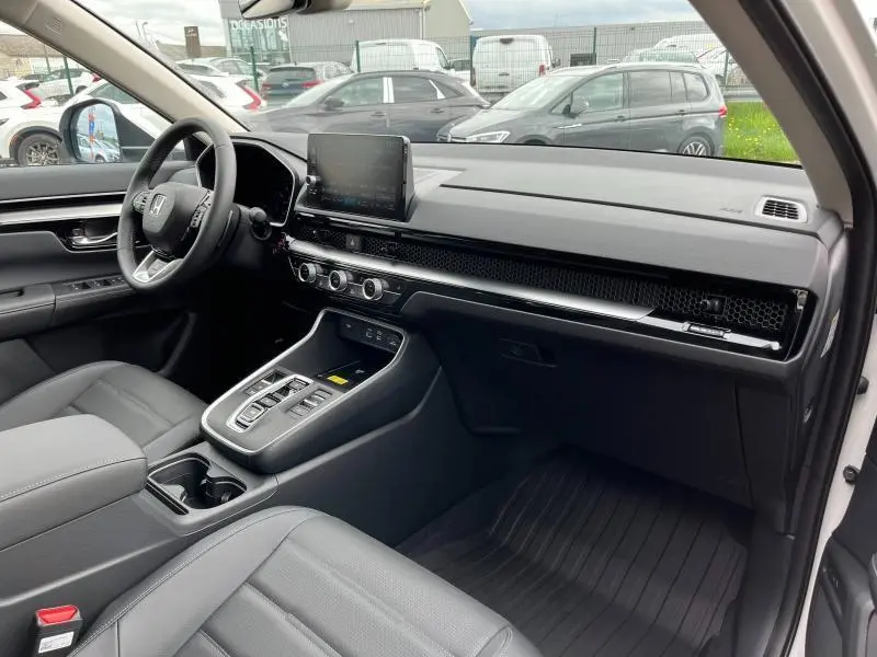 Intérieur noir du Honda CR-V 2024 vu côté conducteur, avec tableau de bord moderne et écran tactile central.