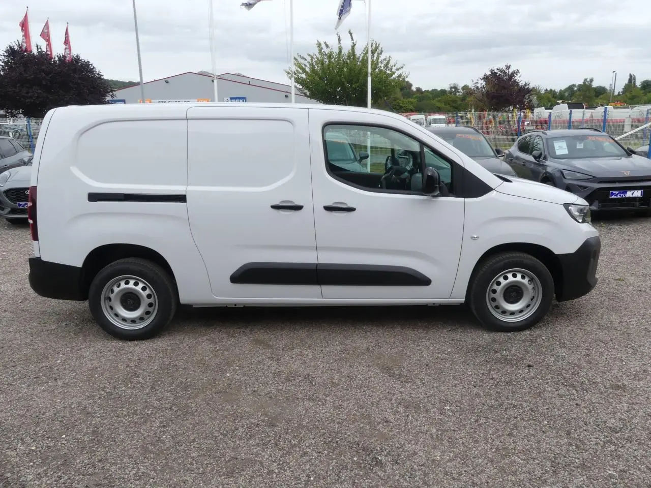 Vue de profil côté gauche d'un utilitaire Peugeot Partner XL blanc avec porte coulissante et jantes tôle grises.