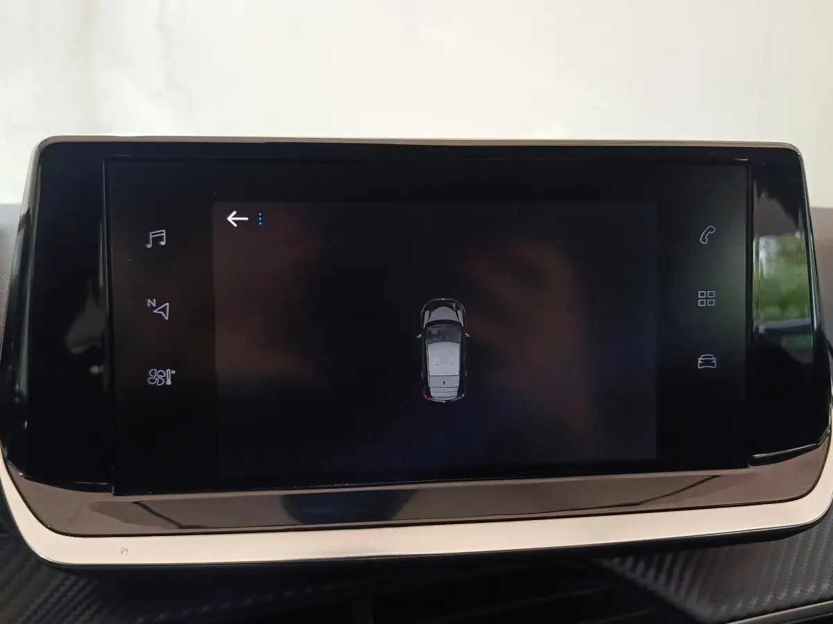 Écran tactile central affichant une vue aérienne du véhicule Peugeot 208 blanc dans l'habitacle.