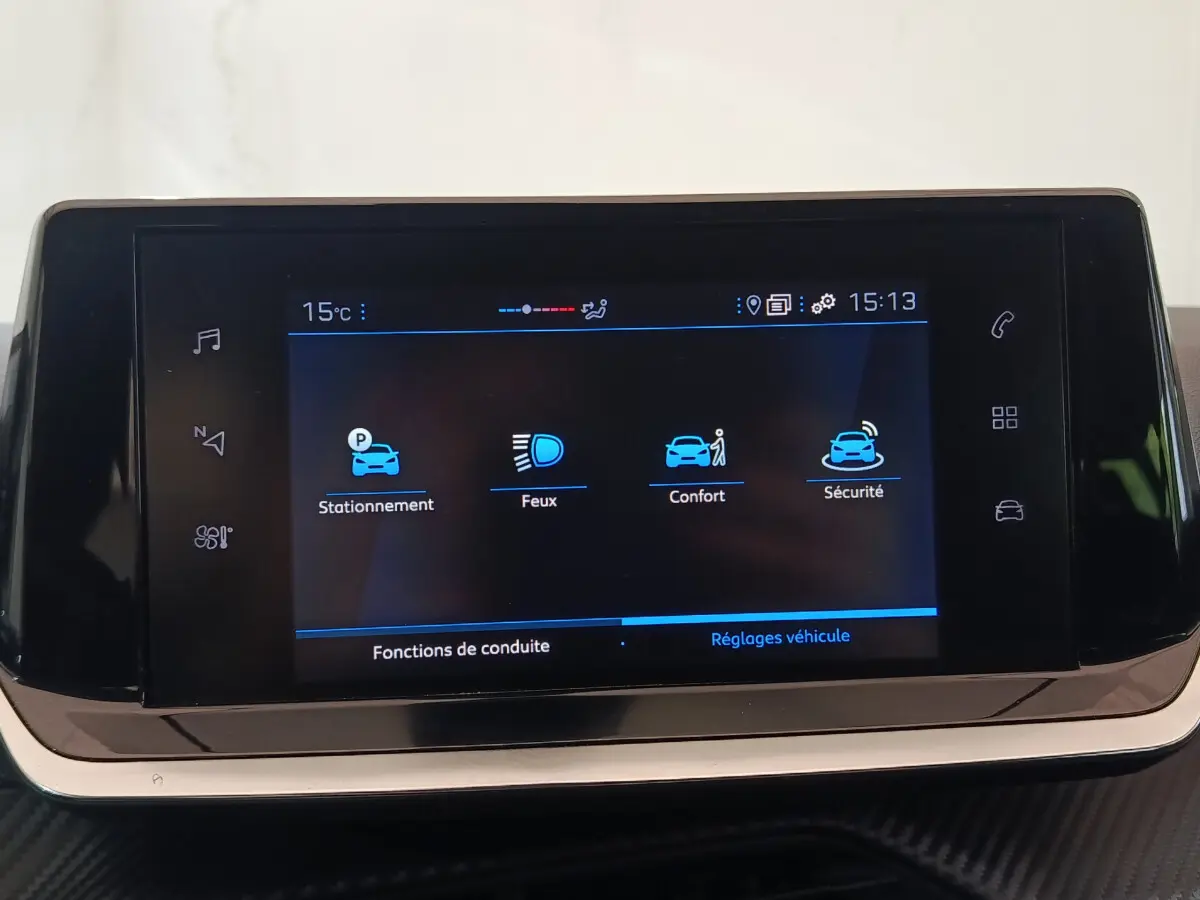 Écran tactile 7 pouces du système multimédia de la Peugeot 208 PureTech 100, affichant les réglages de conduite et sécurité.