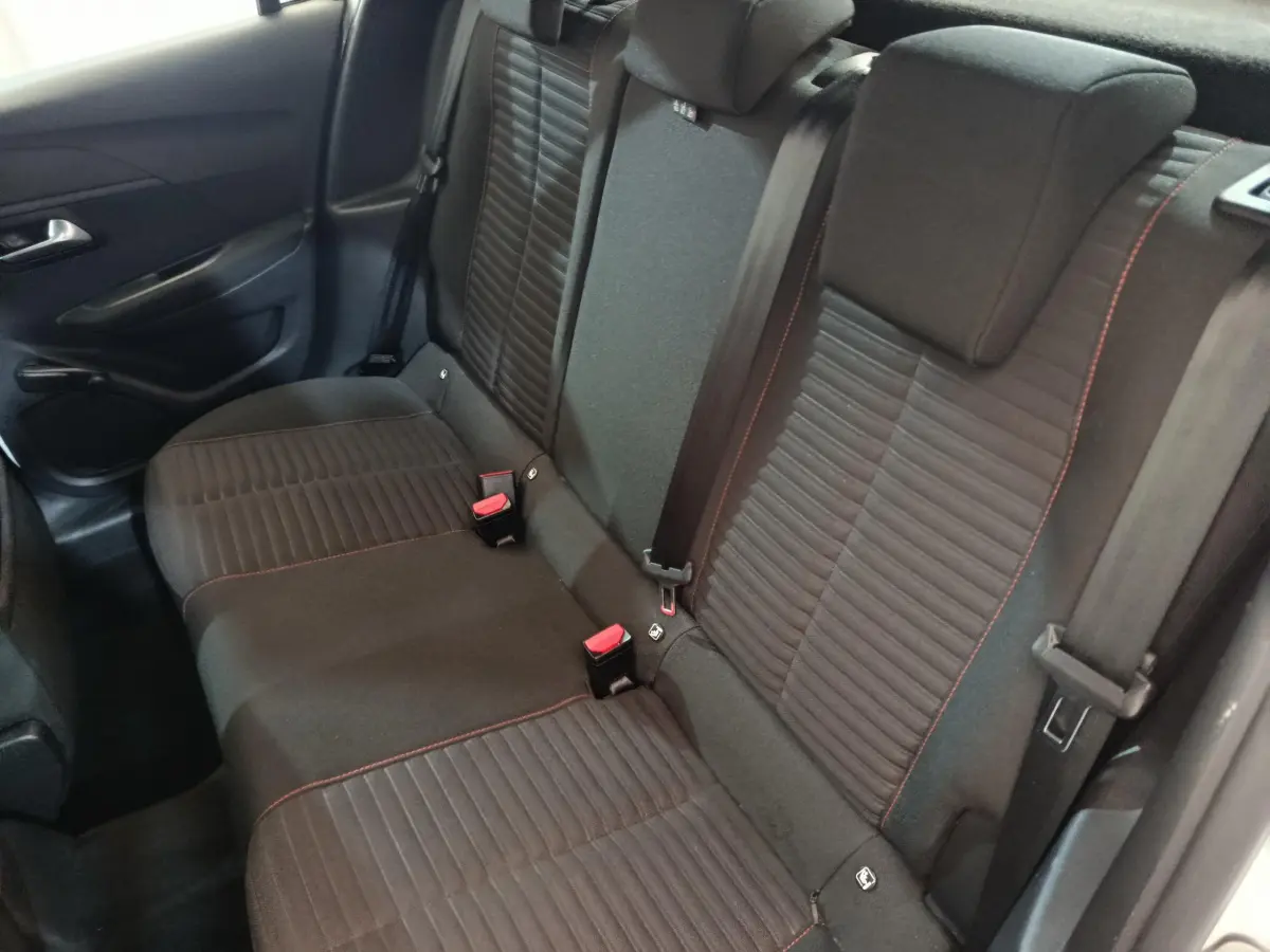 Vue intérieure côté gauche montrant la banquette arrière noire avec surpiqûres rouges du Peugeot 208 blanc 2020 PureTech Active Business