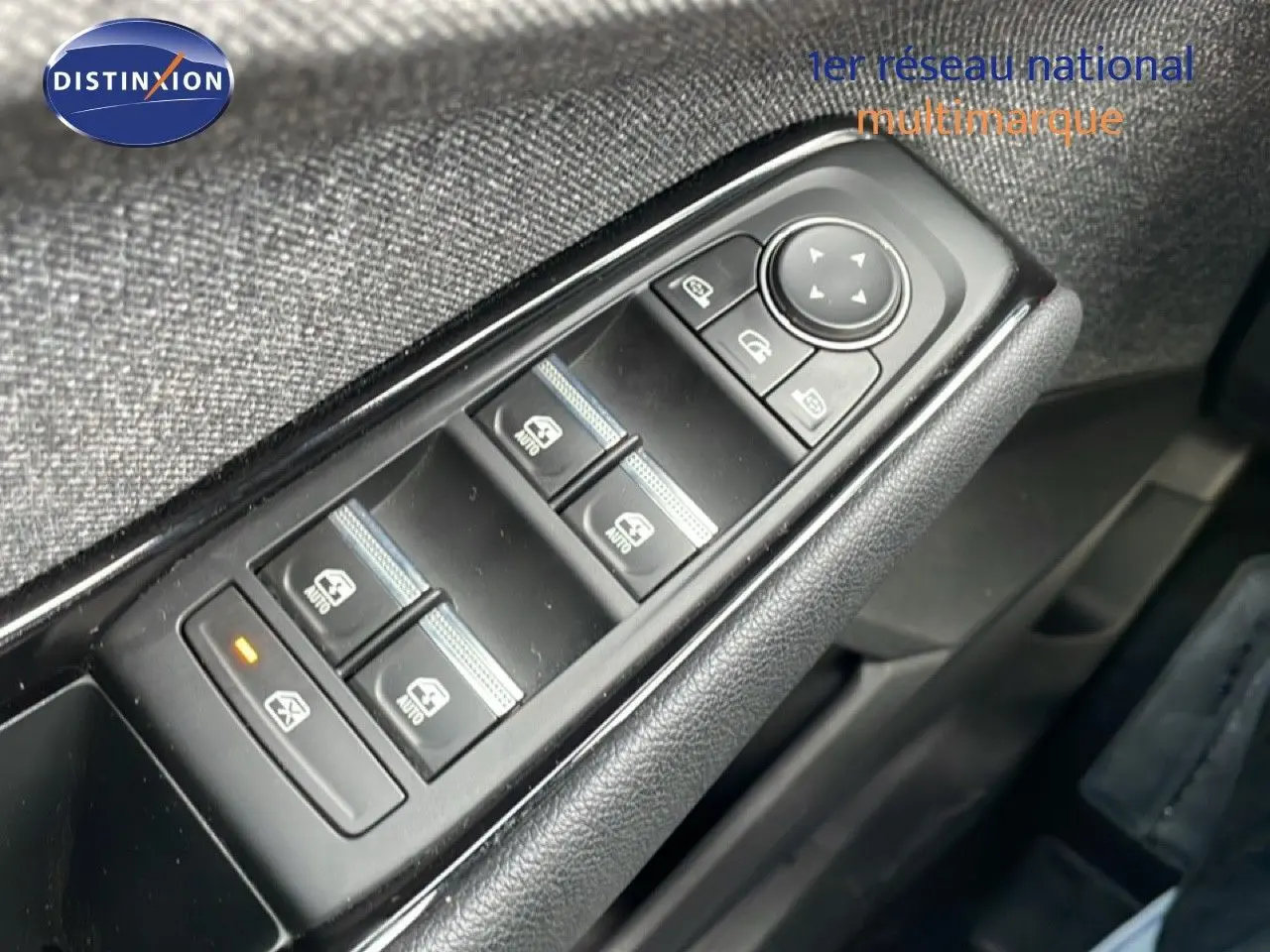 Gros plan sur les commandes des vitres électriques côté conducteur du Renault Espace gris schiste, intérieur tissu noir.