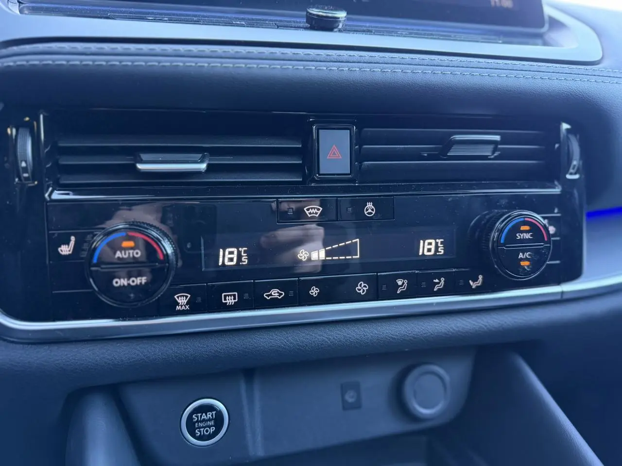 Gros plan sur la console centrale du Nissan Qashqai 2025, affichage digital de la climatisation bi-zone et bouton start/stop.