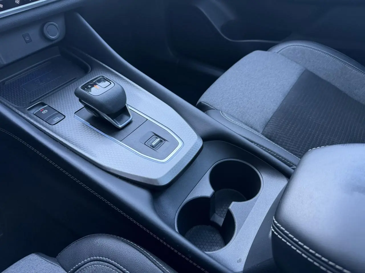 Vue rapprochée de la console centrale du Nissan Qashqai 2025, avec levier de vitesse automatique et accoudoir noir.