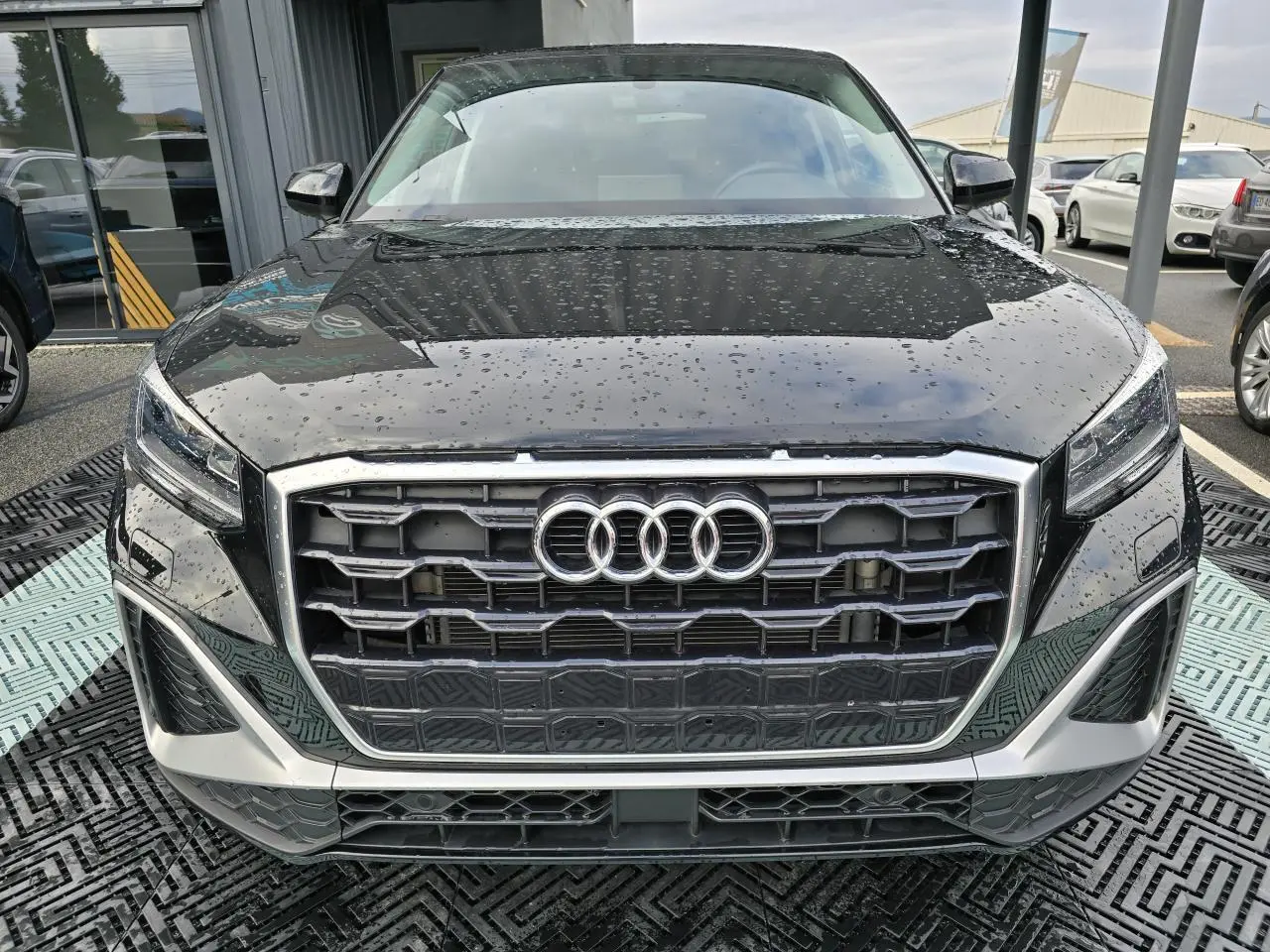 Vue frontale d'un Audi Q2 noir mythic 2023 avec calandre hexagonale et phares LED distinctifs.