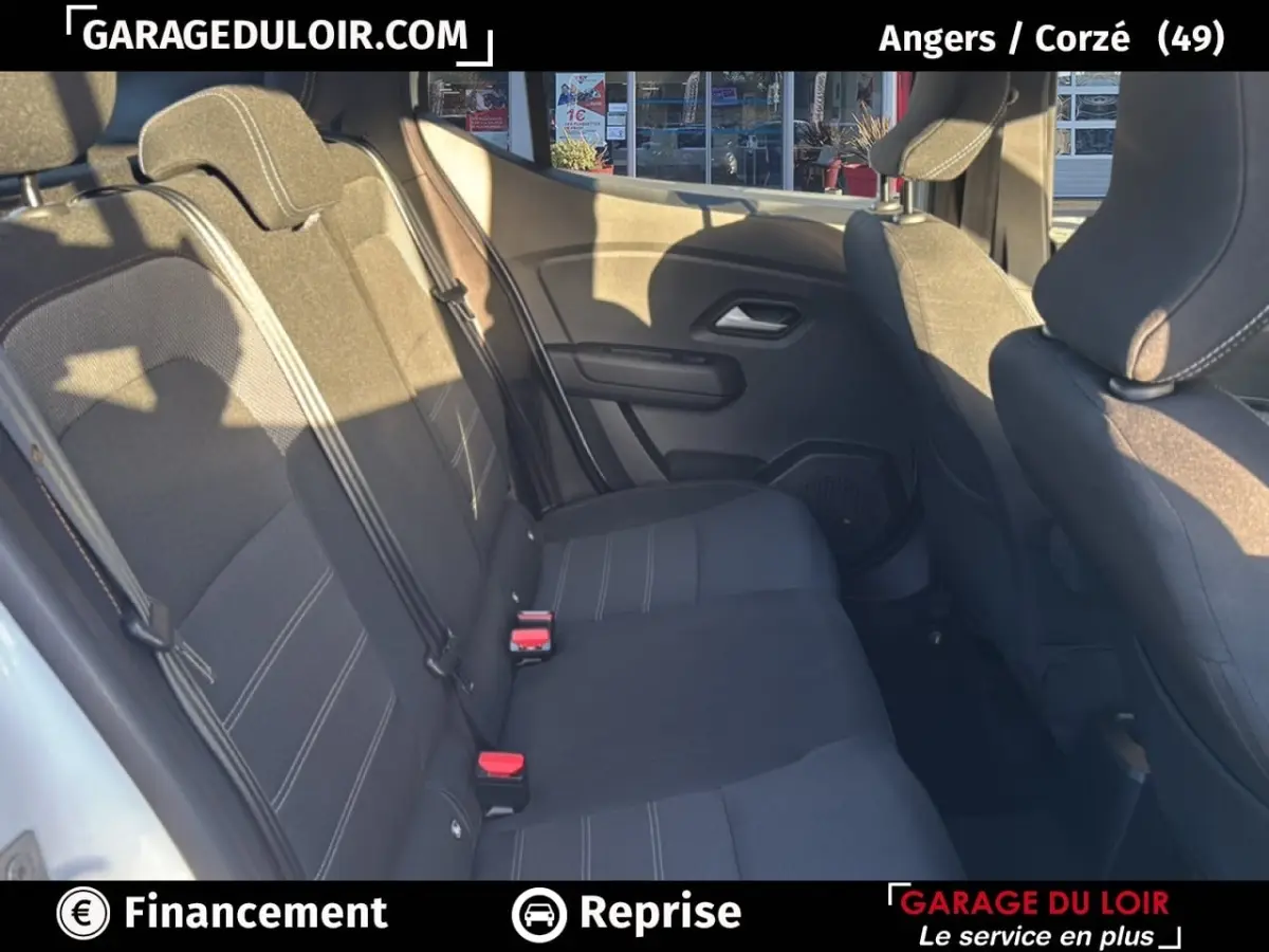 Vue intérieure sur les sièges arrière noirs d'une Dacia Sandero Expression TCe 90 2025, avec ceinture et appuie-têtes visibles.