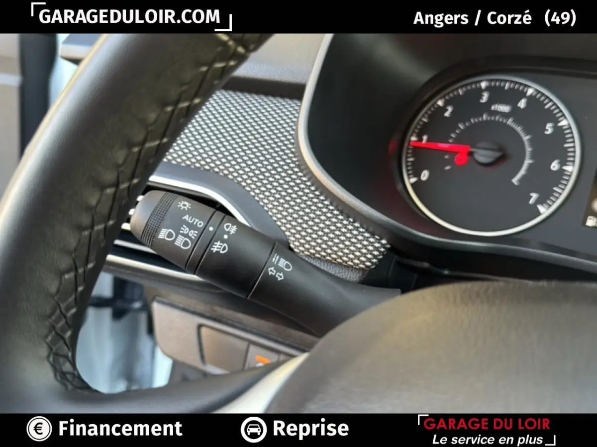 Détail du commodo d’éclairage à gauche du volant dans une Dacia Sandero blanche 2025, version Expression TCe 90.
