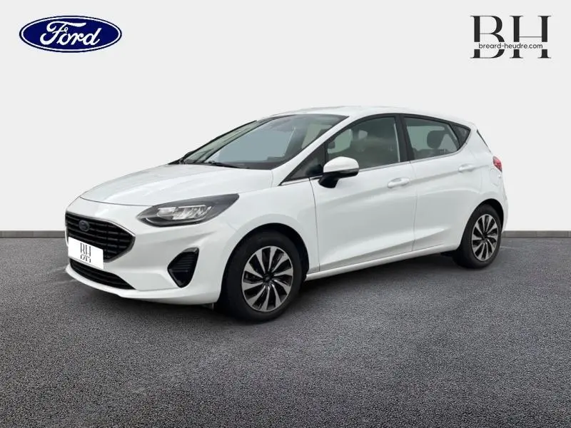 Ford Fiesta blanc glacier vue 3/4 avant droit, calandre noire et jantes alliage distinctives.
