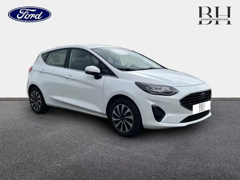Ford Fiesta blanc glacier vue 3/4 avant droit, calandre noire et jantes alliage distinctives.