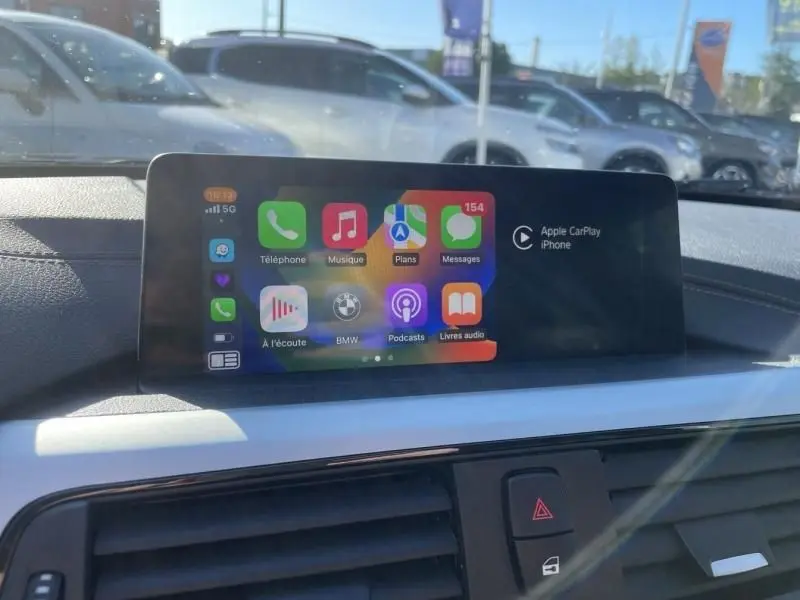 Écran tactile central de la BMW Série 4 Gran Coupé 418 da 2018 affichant Apple CarPlay, intérieur noir.