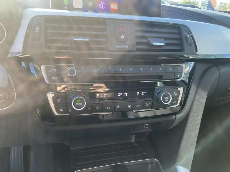 Vue rapprochée de la console centrale de la BMW Série 4 Gran Coupé 418 da 2018, avec commandes climatisation et écran tactile.