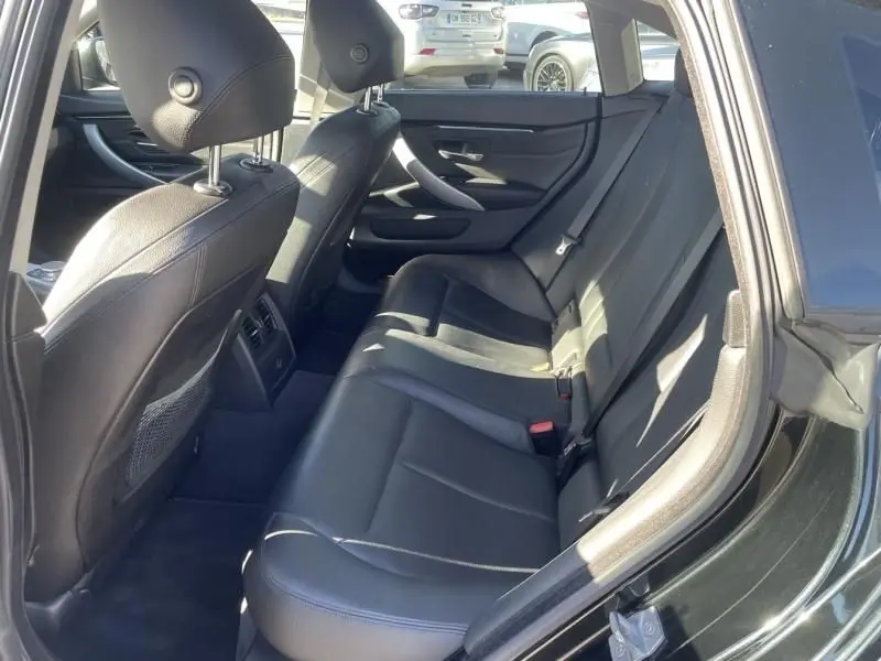 Vue intérieure côté droit sur les sièges arrière en cuir noir d'une BMW Série 4 Gran Coupé 418 da 2018 noir métal.
