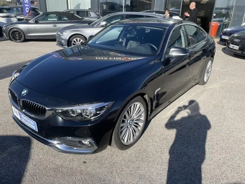 BMW Série 4 Gran Coupé noir métal vue 3/4 avant droit, avec jantes alliage et calandre caractéristique BMW.