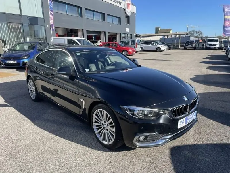 BMW Série 4 Gran Coupé 418 da noir métal vue 3/4 avant, avec jantes alliage et calandre caractéristique BMW.