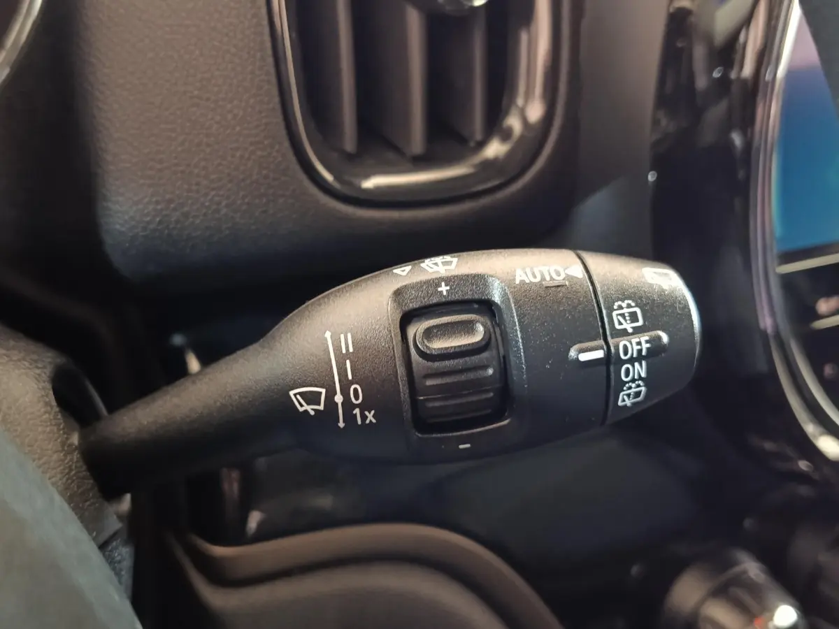 Gros plan sur la commande des essuie-glaces du MINI Countryman Cooper SE noir, avec marquages blancs et bouton central.