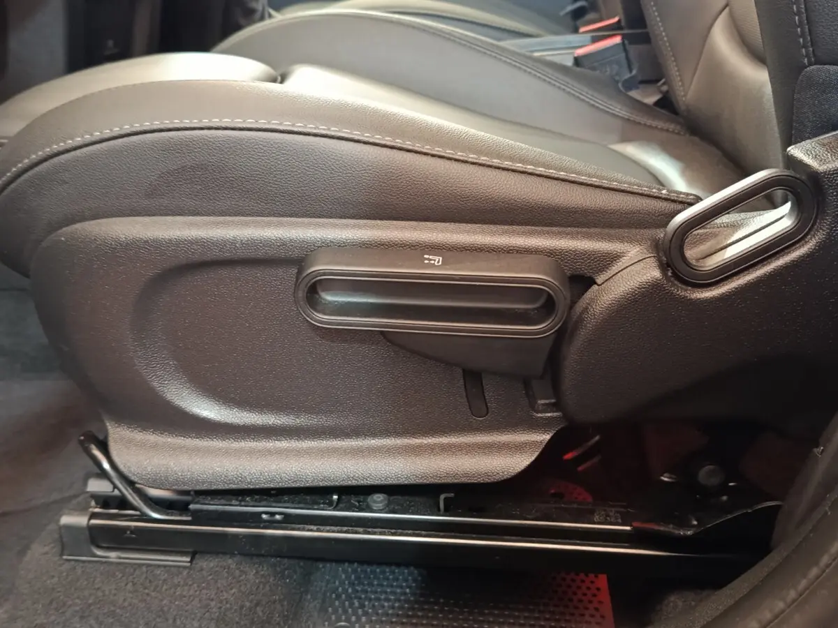 Détail côté gauche du siège avant noir du MINI Countryman Cooper SE 2023, avec commande de réglage manuelle.
