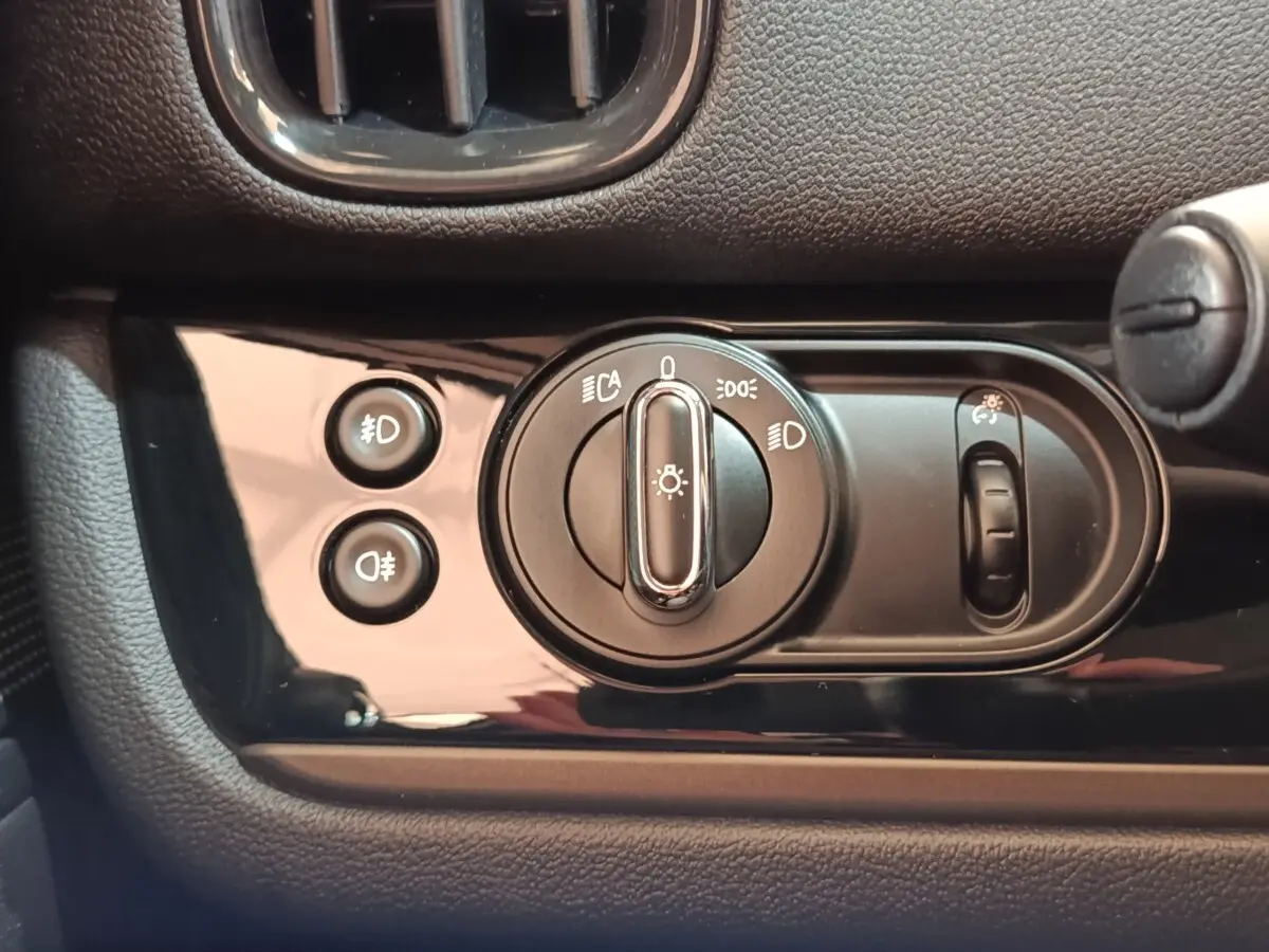 Gros plan sur les commandes d’éclairage du tableau de bord noir du MINI Countryman Cooper SE 2023.