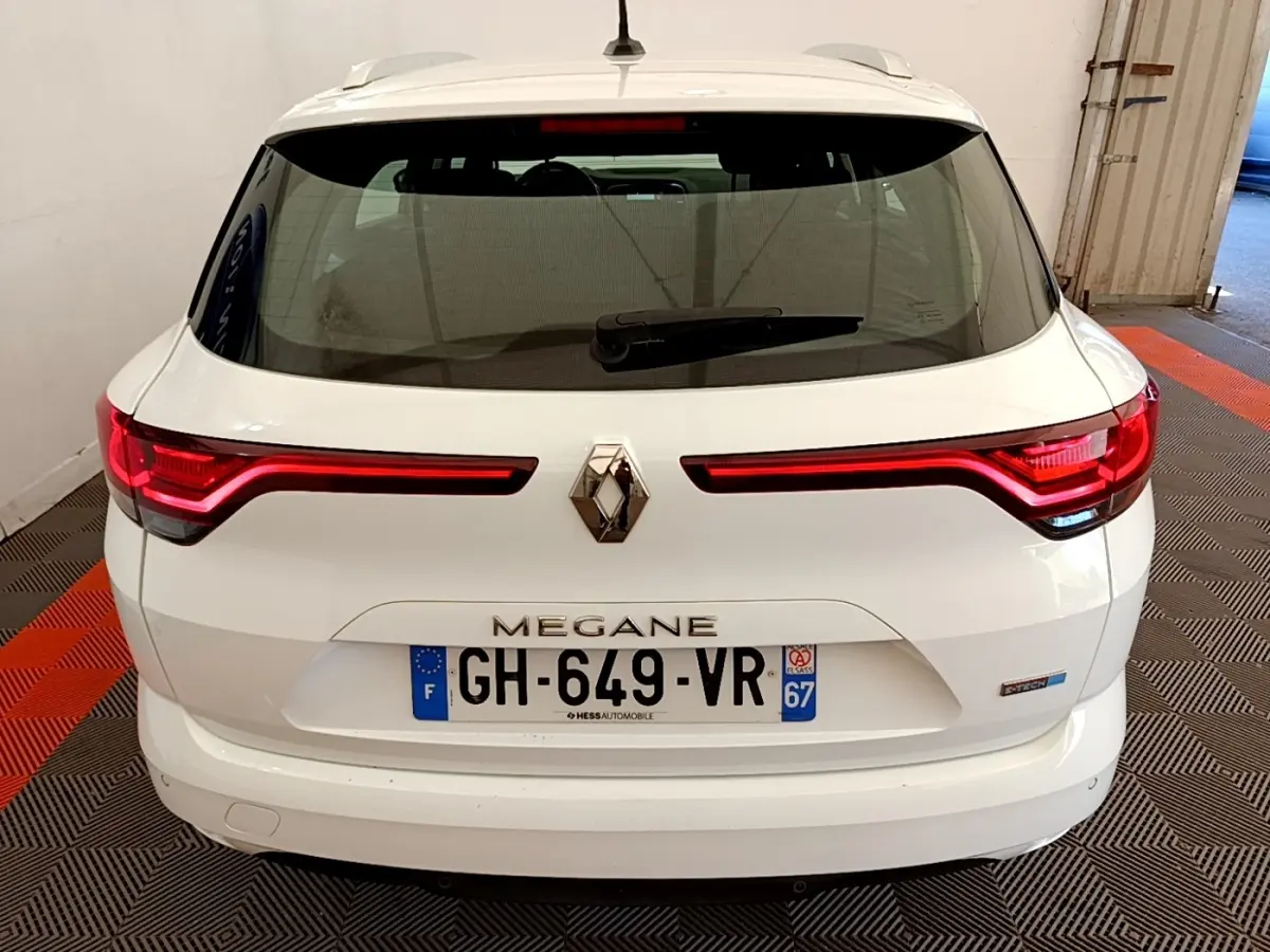 Vue arrière d'une Renault Megane Business E-Tech hybride rechargeable blanche, avec feux LED et logo centré.