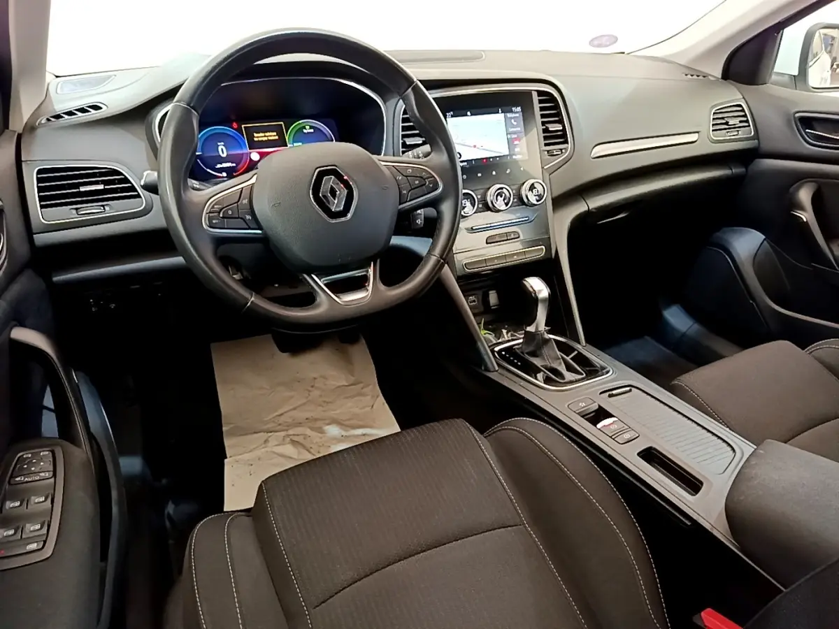 Vue intérieure avant de la Renault Mégane Business E-Tech hybride, tableau de bord noir avec écran tactile et volant multifonctions.