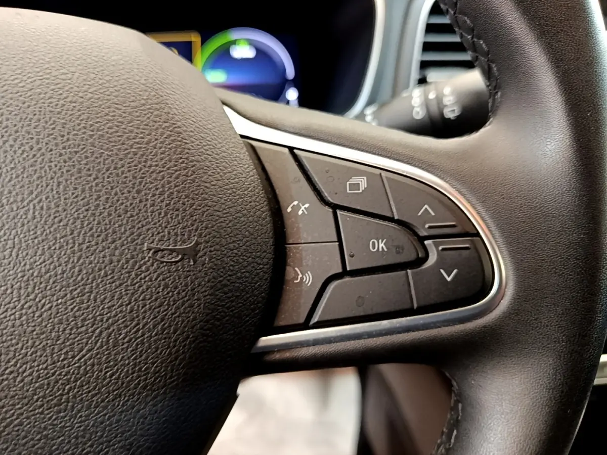 Gros plan sur les commandes multifonctions du volant noir de la Renault Mégane Business E-Tech hybride rechargeable 2022.