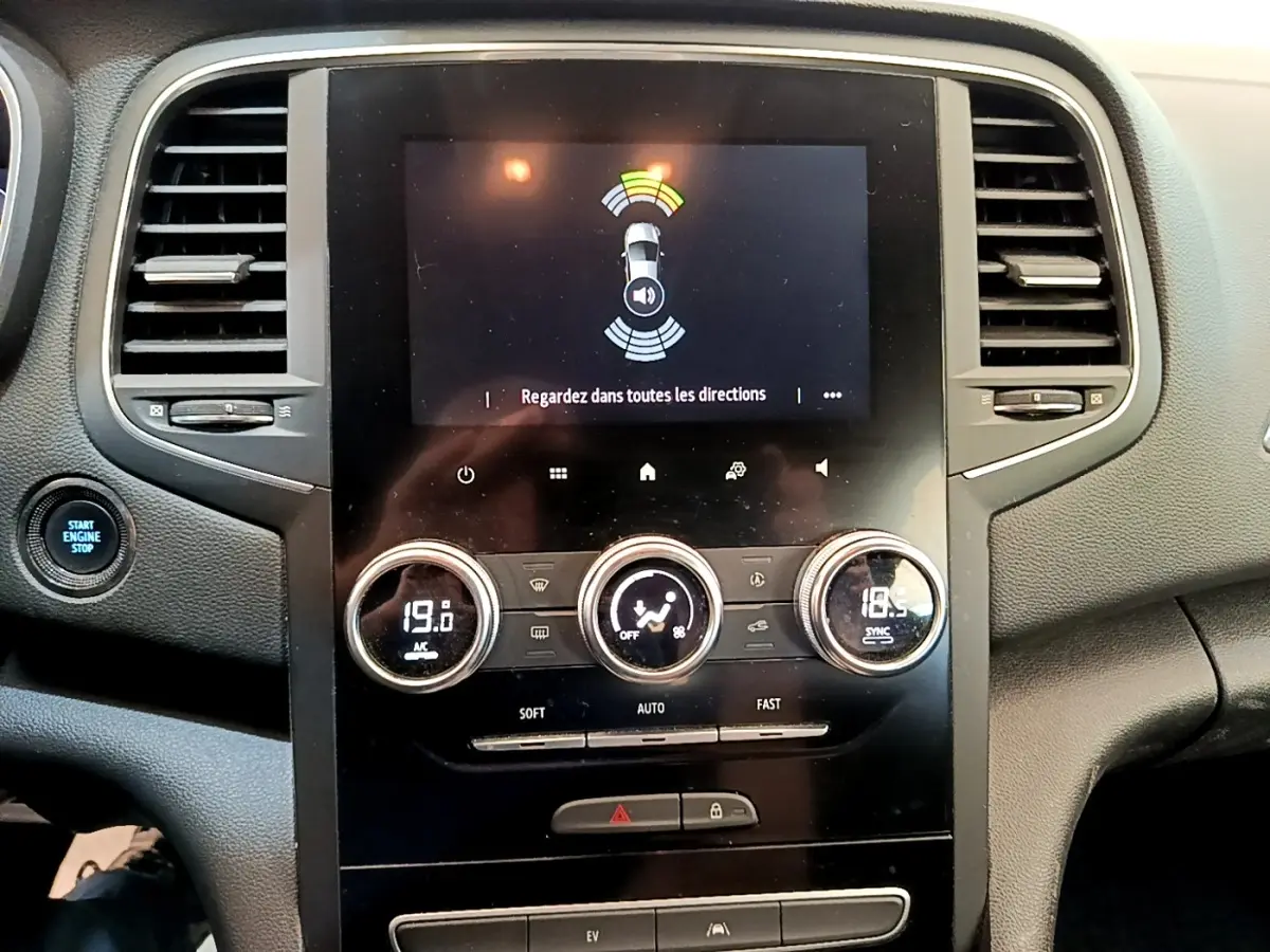 Vue rapprochée du tableau de bord noir de la Renault Mégane Business E-Tech hybride, avec écran tactile et commandes climatisation digitales.