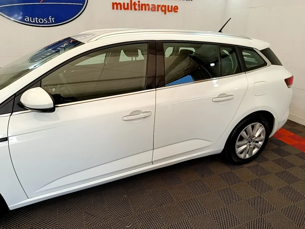 Profil droit de la Renault Mégane Business E-Tech hybride rechargeable blanche, avec jantes alliage et rétroviseurs blancs.