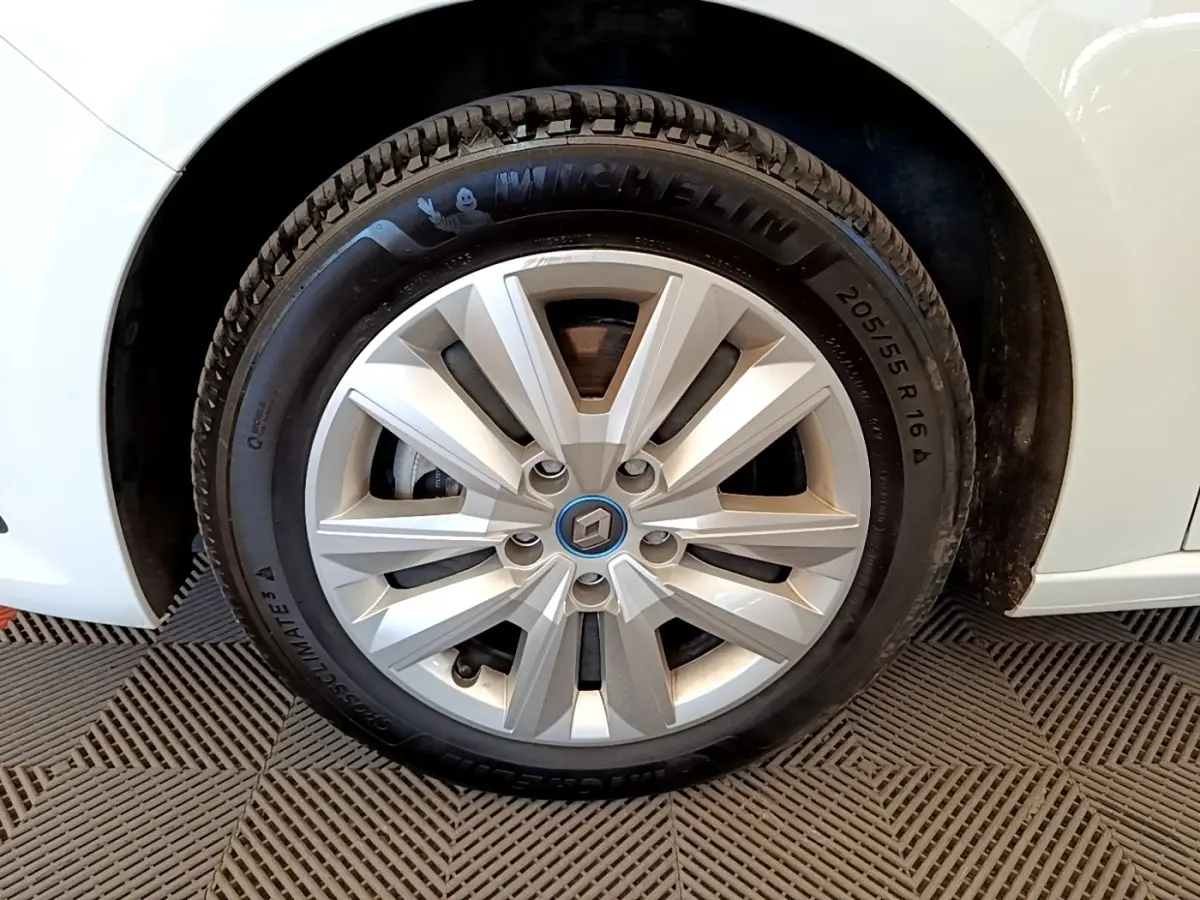 Gros plan sur la roue avant gauche blanche d’une Renault Mégane Business E-Tech hybride rechargeable avec jante argentée.
