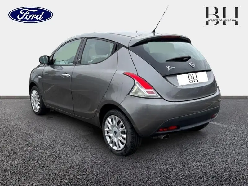 Vue 3/4 arrière droite d'une Lancia Ypsilon gris Argento avec feux arrière distinctifs et becquet noir.