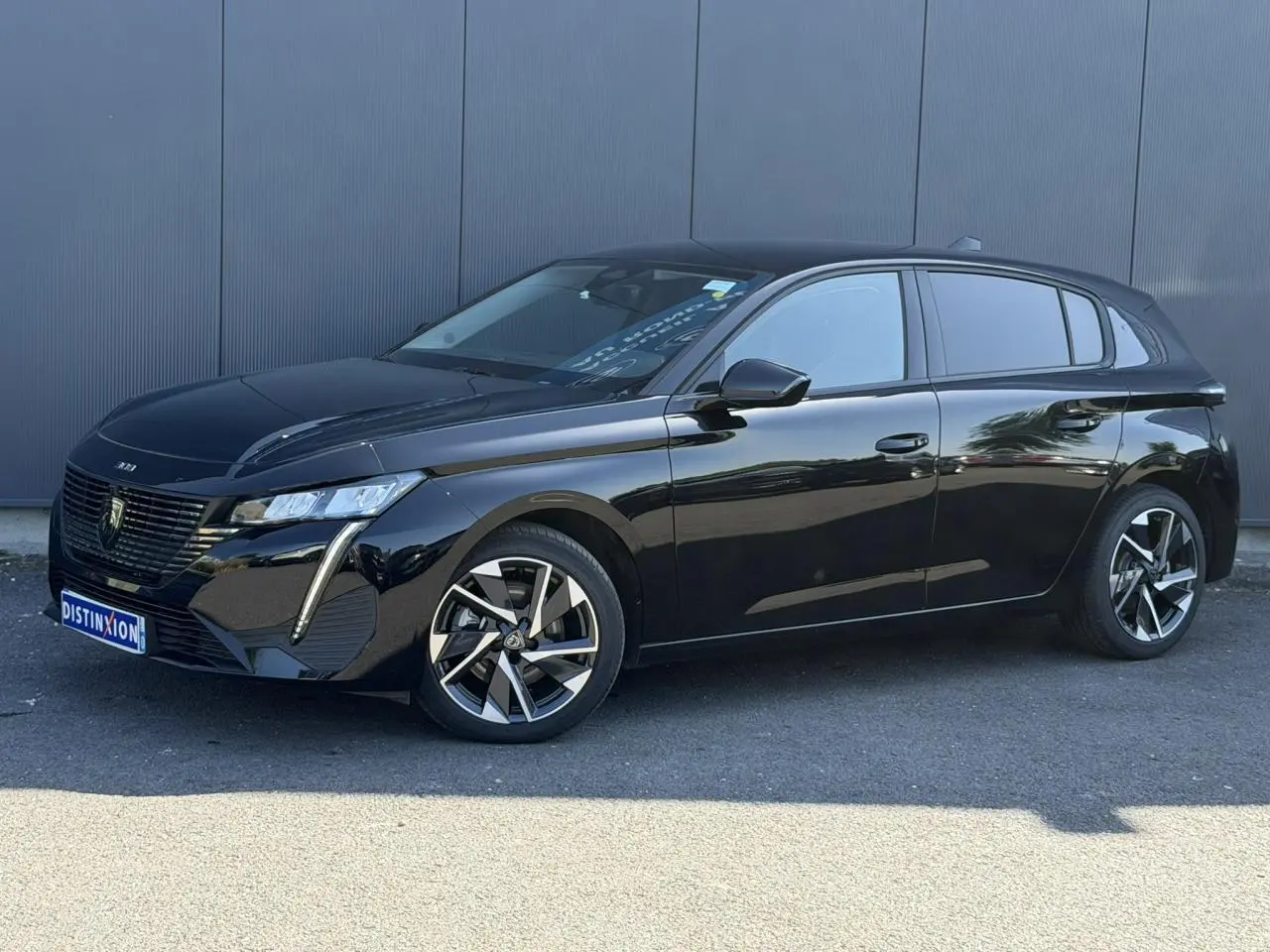 Peugeot 308 Hybrid 2025 noir Perla vue 3/4 avant, avec jantes alliage 17'' et feux LED distinctifs.