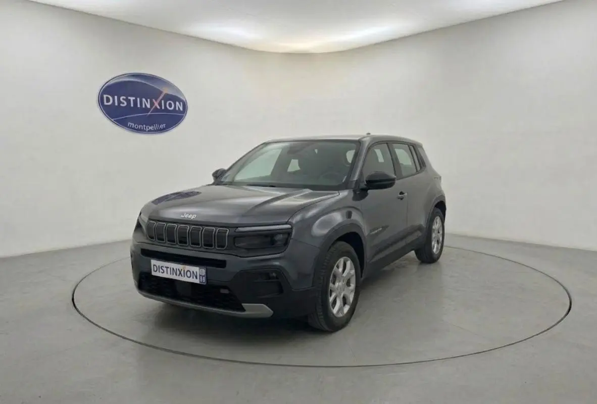 Jeep Avenger électrique gris en 3/4 avant droit, SUV compact avec calandre distinctive et jantes argentées.