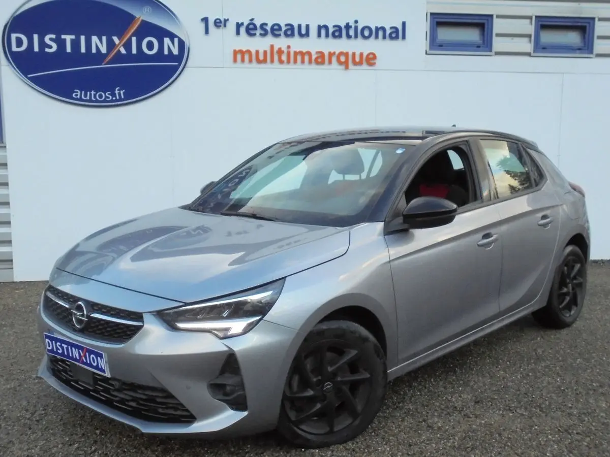 Opel Corsa gris quartz métal vue 3/4 avant droit, avec jantes noires et calandre distinctive.