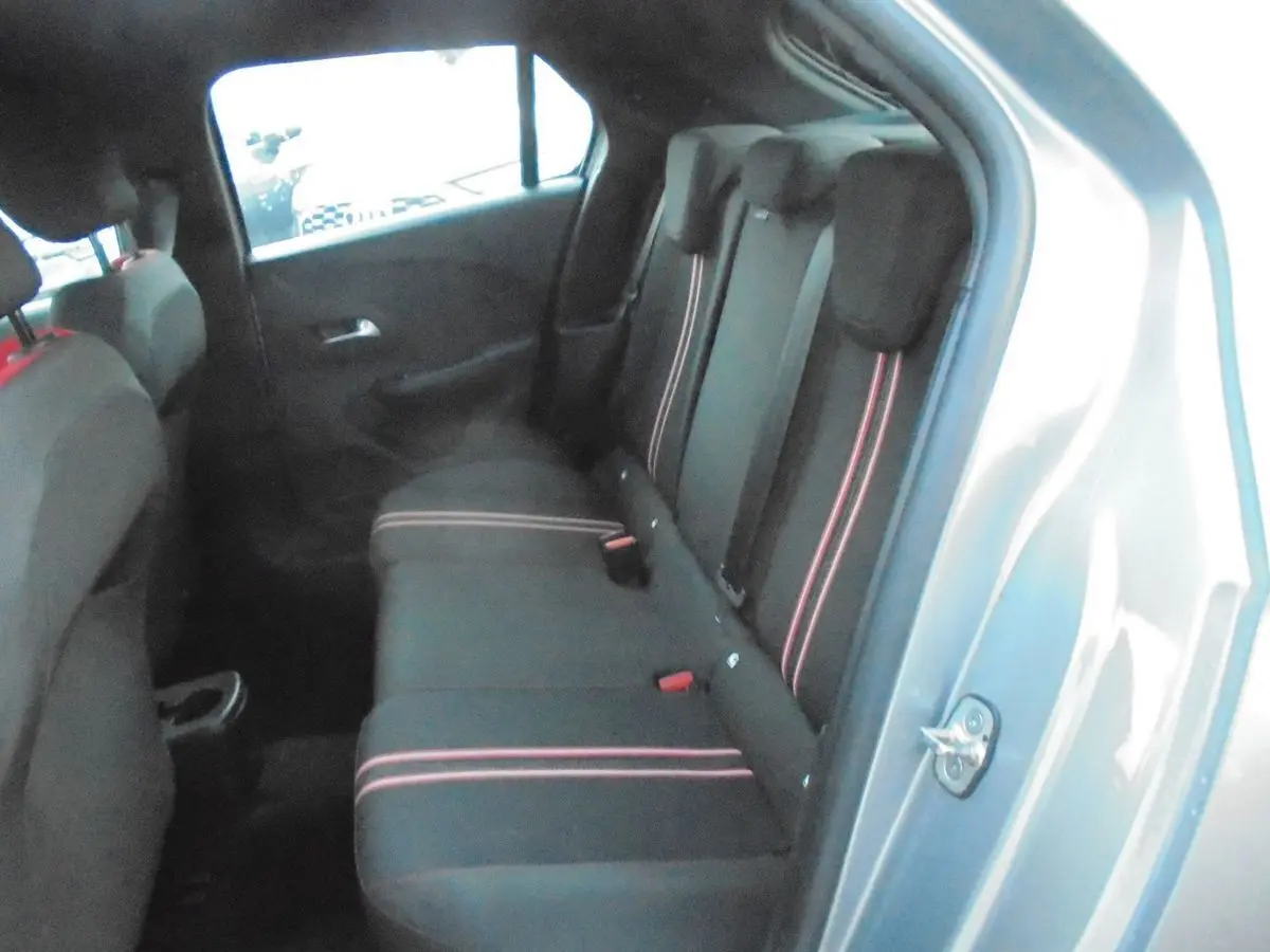 Vue intérieure côté droit sur les sièges arrière noirs avec bandes rouges d'une Opel Corsa gris quartz métal.
