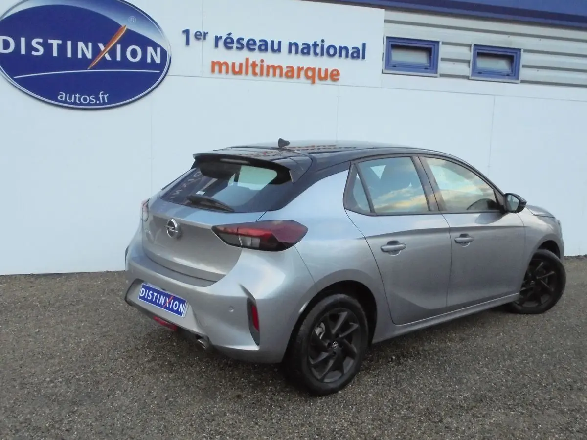 Opel Corsa gris quartz métal vue 3/4 arrière côté droit, avec toit noir contrasté et jantes noires.