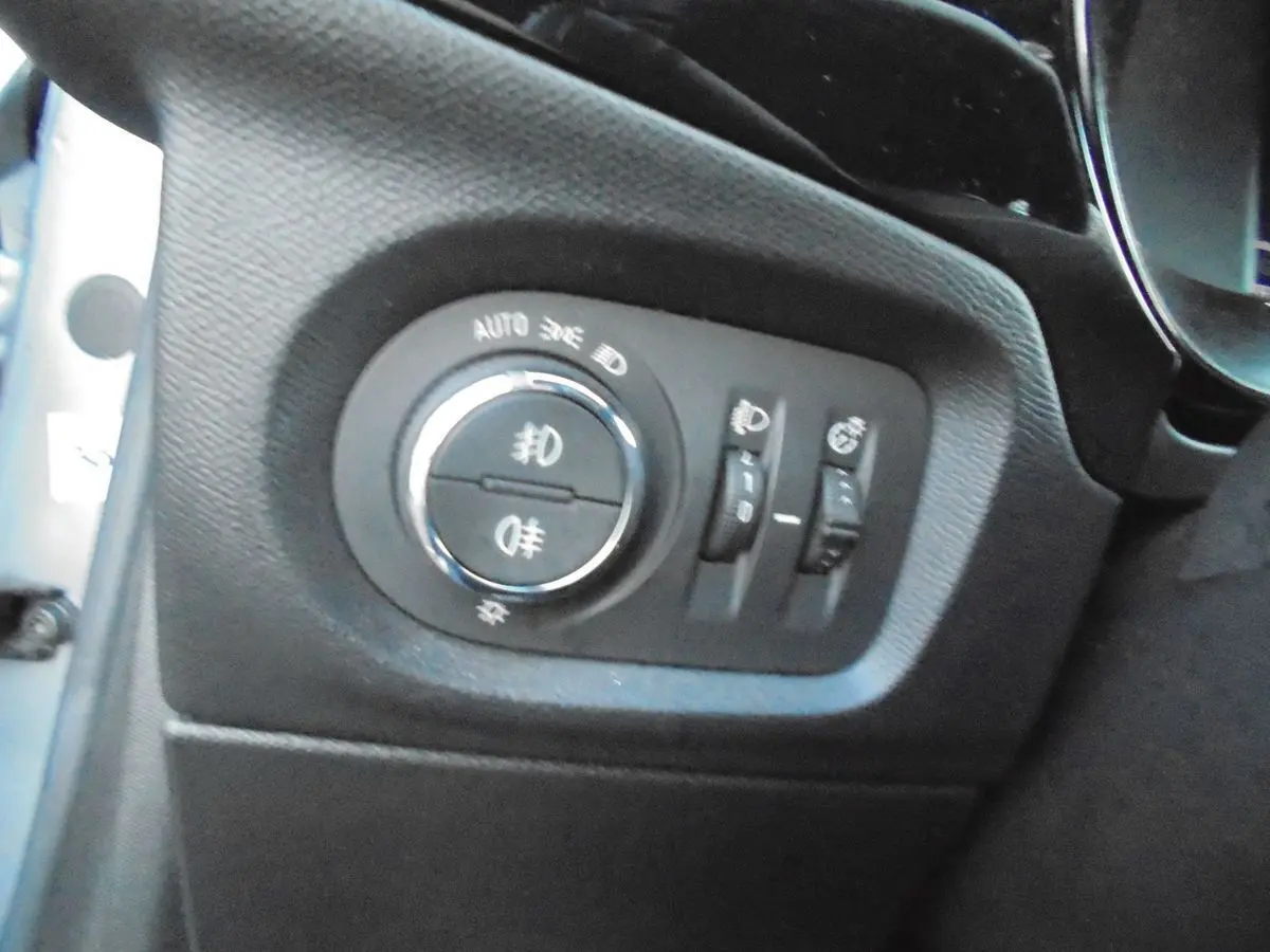 Gros plan sur les commandes d'éclairage intérieures de l'Opel Corsa gris quartz, côté gauche du tableau de bord.
