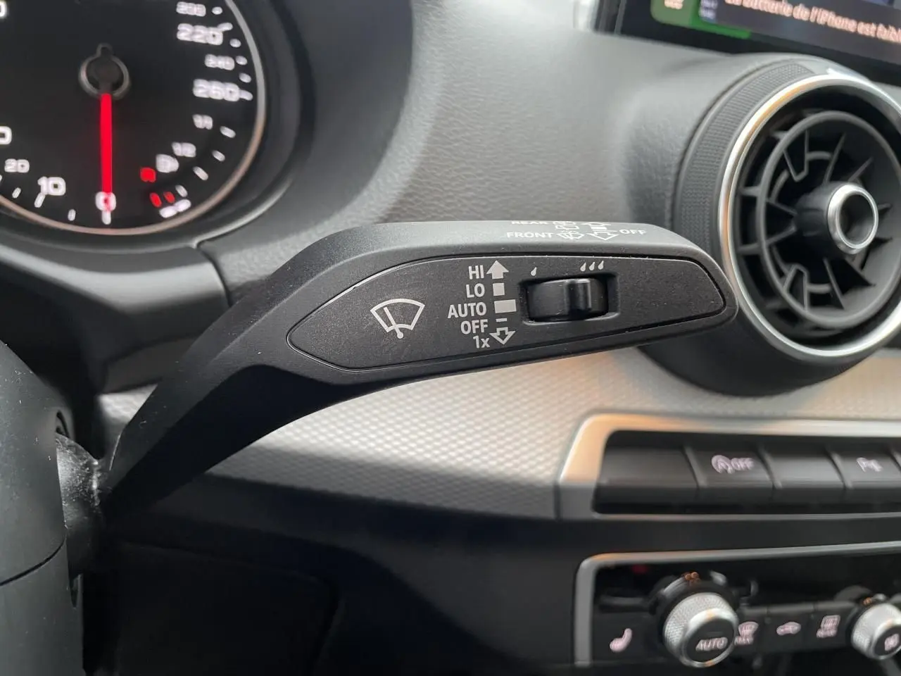 Gros plan sur la commande d’essuie-glace côté gauche du tableau de bord d’un Audi Q2 noir Mythic 2023.