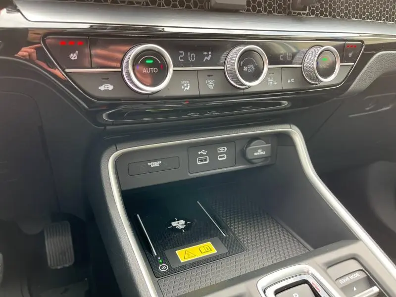 Détail de la console centrale du Honda CR-V 2024 blanc nacré, avec commandes climatisation et recharge sans fil visible