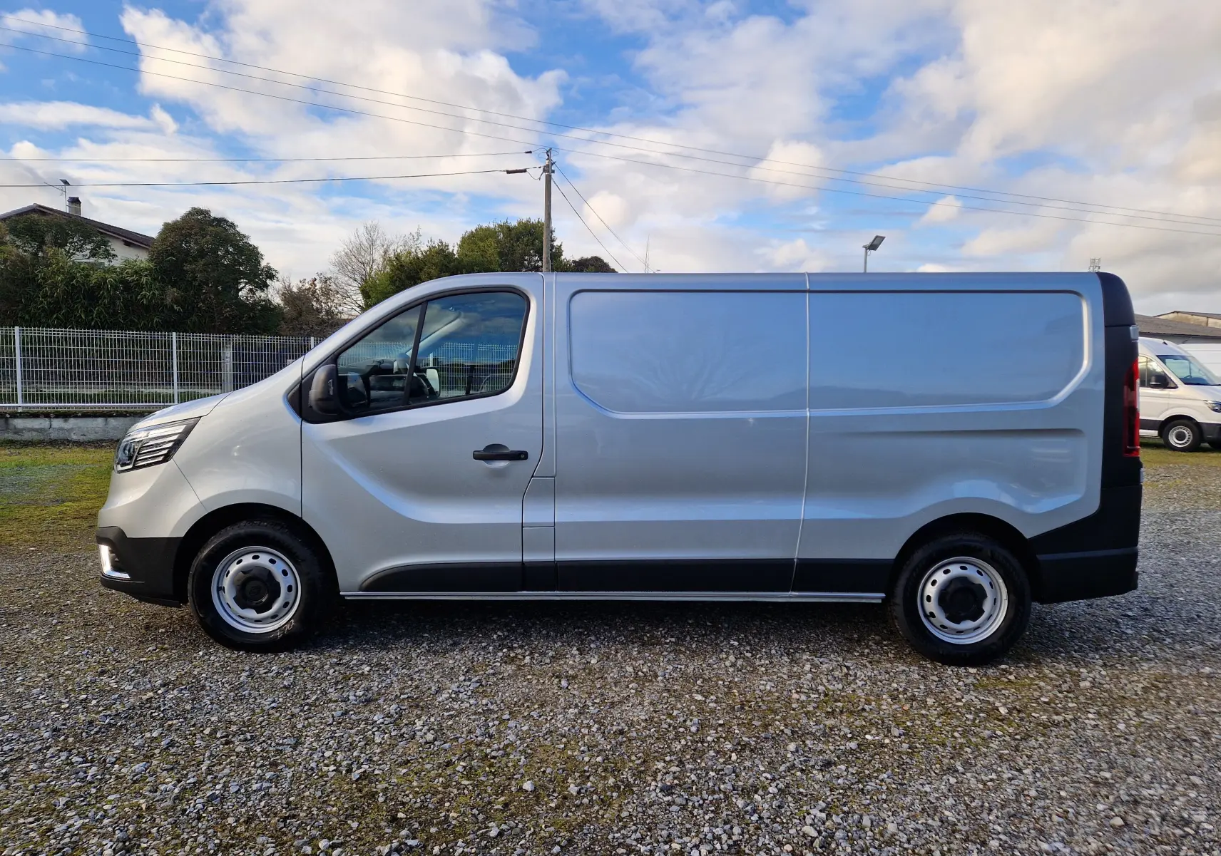 Vue de profil côté gauche d’un Renault Trafic Fourgon gris Highland 2025 avec carrosserie L2H1 et jantes acier.