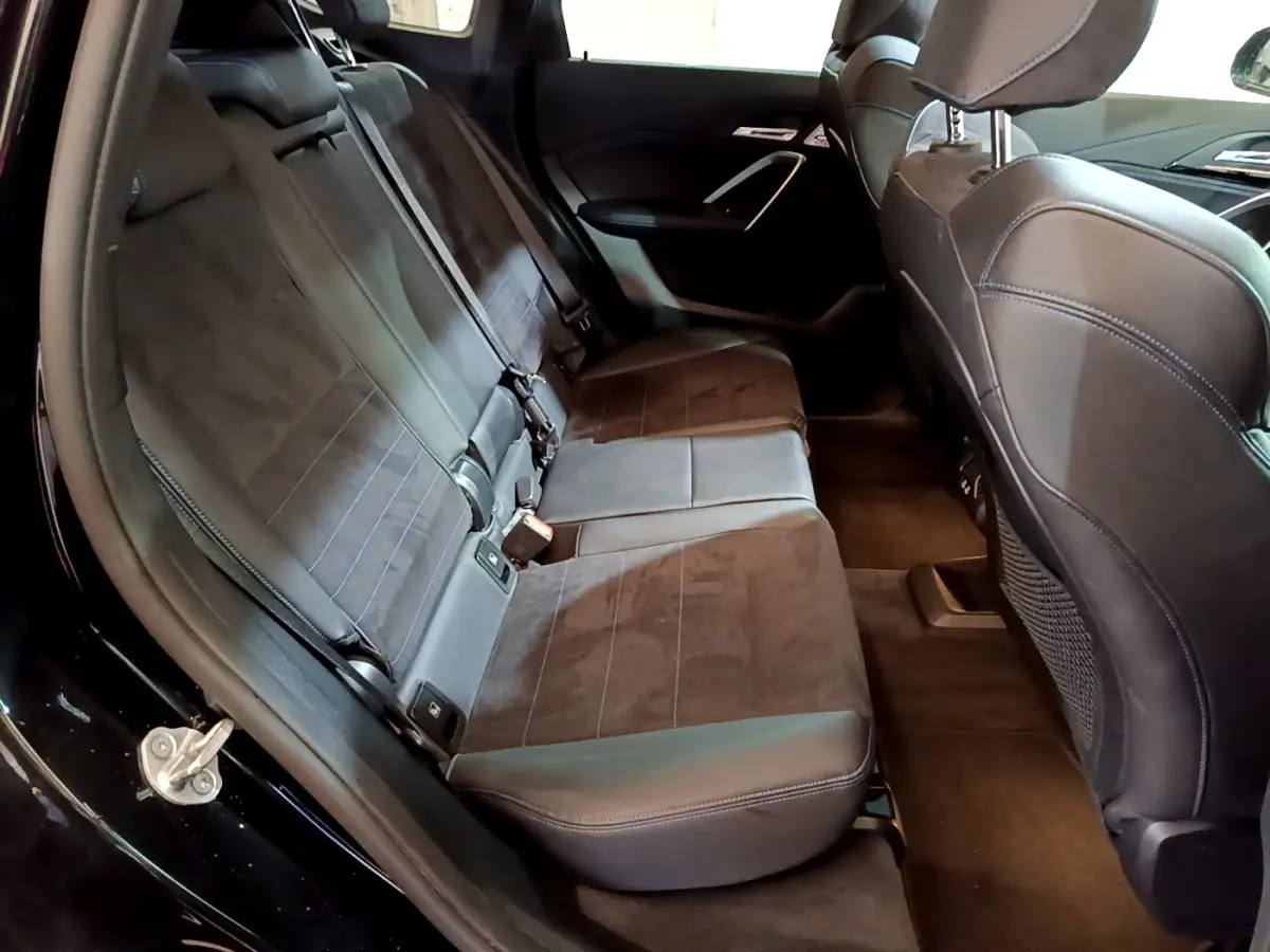 Vue intérieure côté gauche sur la banquette arrière en tissu noir du BMW X1 xDrive23i M Sport 2023.