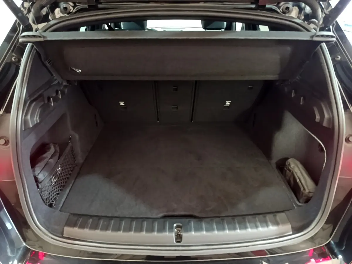 Coffre ouvert noir d'un BMW X1 xDrive23i M Sport 2023, montrant un espace de chargement propre et spacieux.