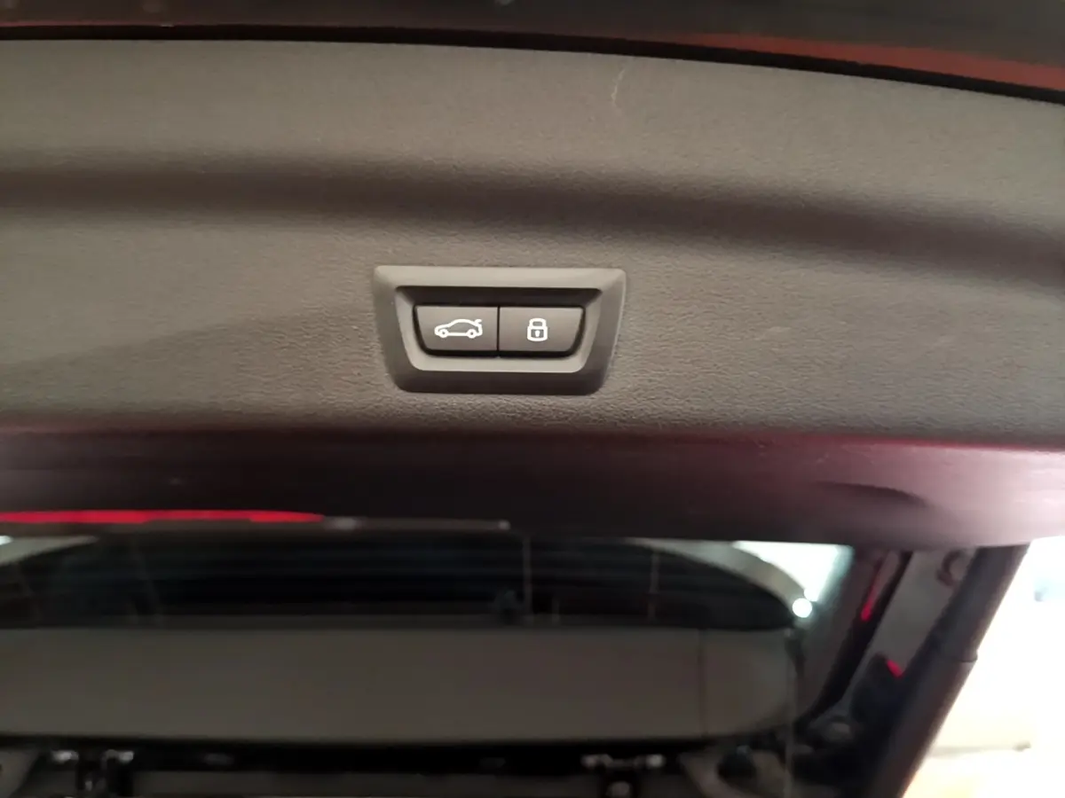 Gros plan sur les boutons d'ouverture et de verrouillage électrique du coffre du BMW X1 noir xDrive23i M Sport 2023.