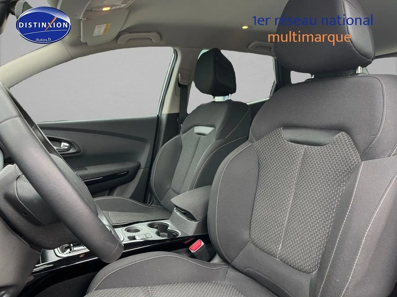 Vue intérieure côté conducteur du Renault Kadjar 2018, sièges tissu carbone foncé avec accoudoir central et console.