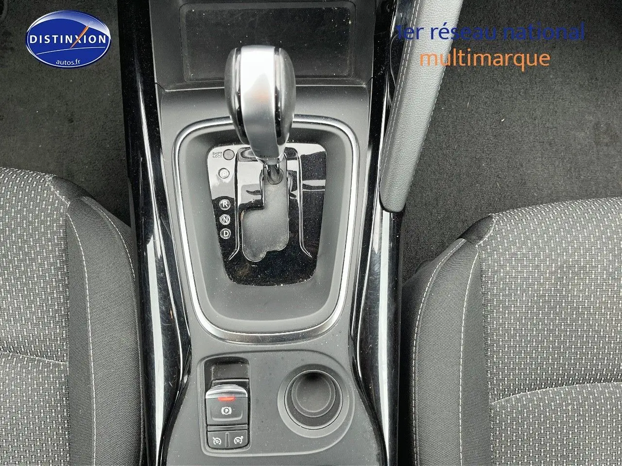 Vue plongeante sur la console centrale noire avec levier de boîte auto et sièges tissu gris du Renault Kadjar 2018.