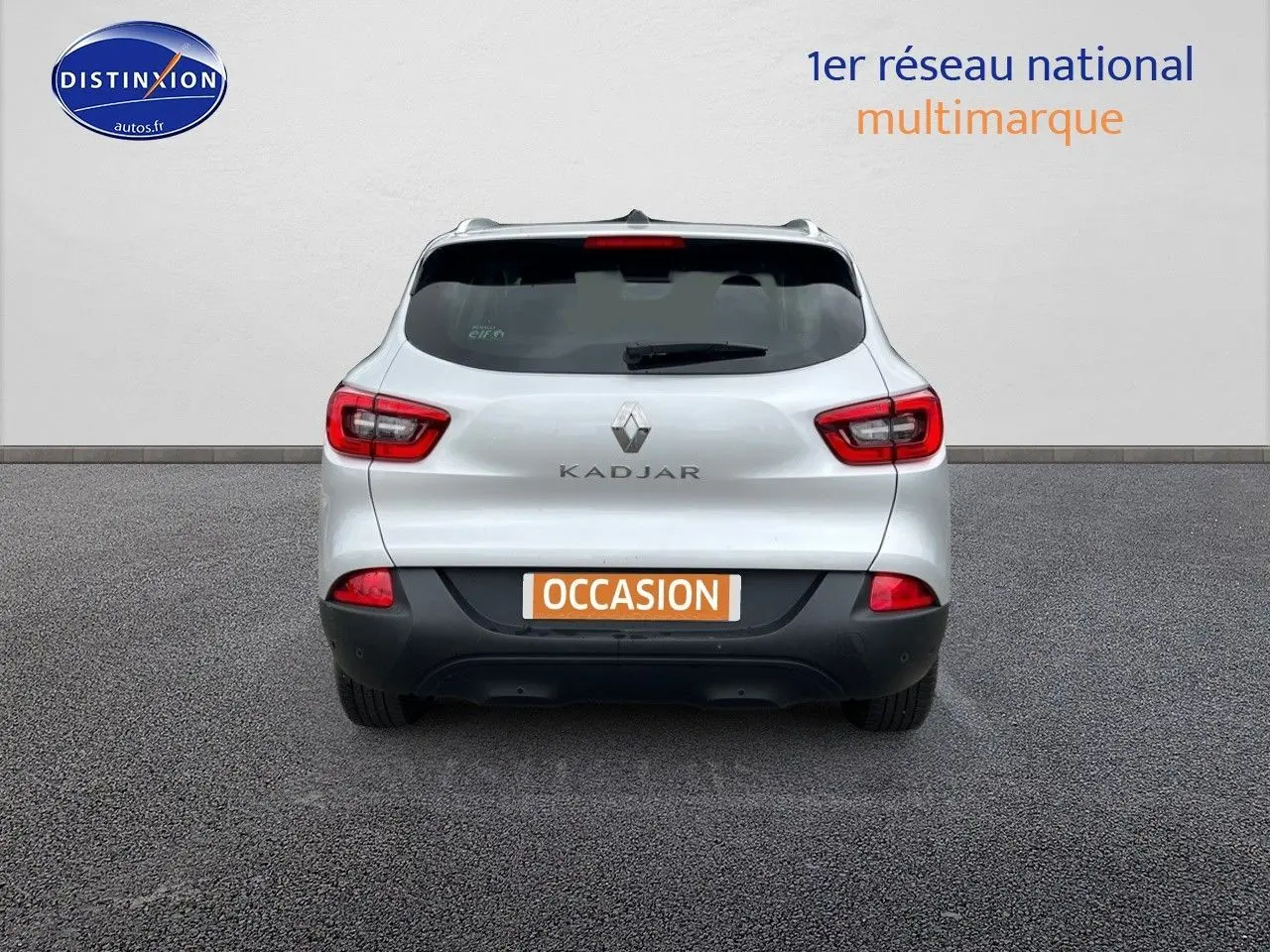 Vue arrière d'un Renault Kadjar gris platine avec feux rouges et plaque "OCCASION" sur fond neutre.